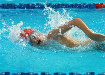 uomo in piscina che esegue un allenamento nuoto intermedio con cuffia e occhialetti da piscina