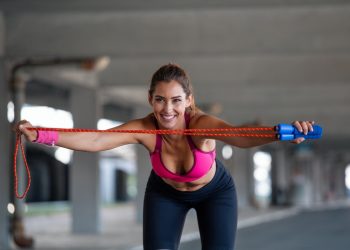 Donna in palestra che si riscalda con la corda prima di eseguire salto con la corda