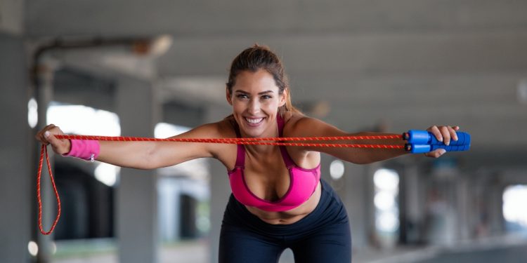 Donna in palestra che si riscalda con la corda prima di eseguire salto con la corda