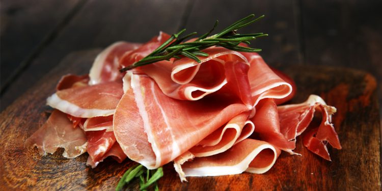 calorie del prosciutto crudo: 4 fette di prosciutto su un tagliare