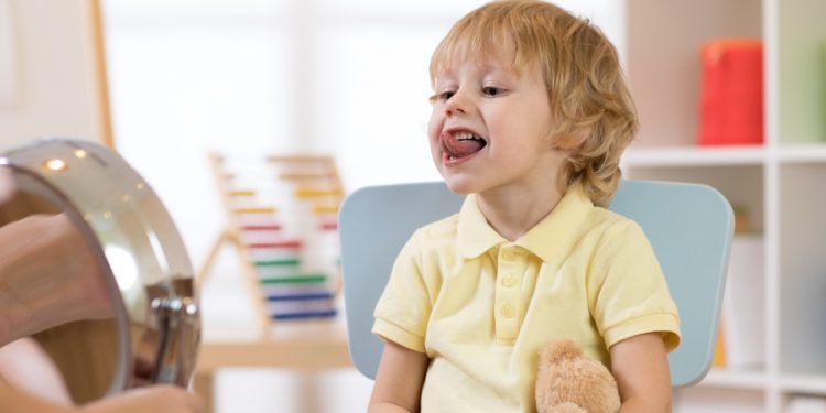 un bambino mostra la lingua mentre fa gli esercizi per i DSA