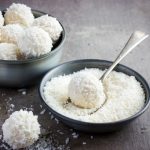 Una ciotola colma di farina di cocco e alcune palline dolci al cocco