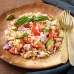 un piatto di legno tondo con una porzione di panzanella fresca