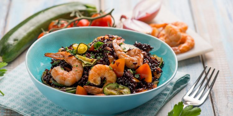 una scodella turchese con riso nero e gamberetti