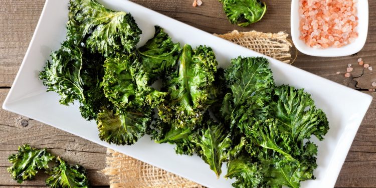 su base di legno piatto bianco rettangolare con foglie di cavolo nero