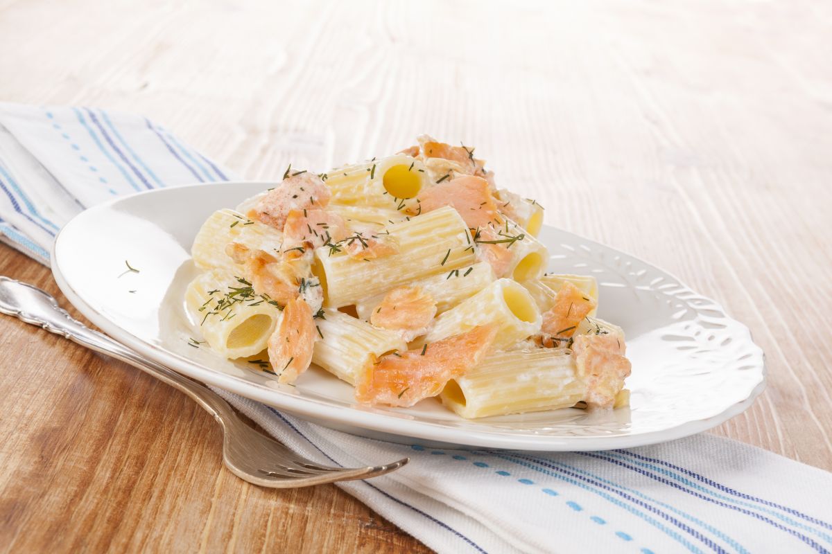 piatto di rigatoni al salmone e una forchetta