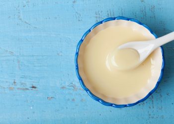 primo piano su sfondo blu di una scodella con latte condensato
