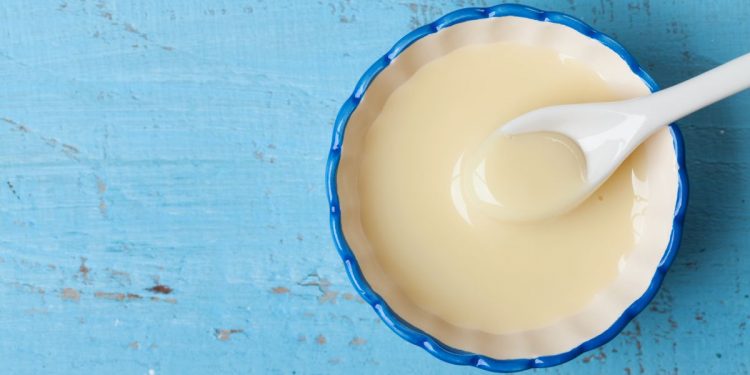 primo piano su sfondo blu di una scodella con latte condensato