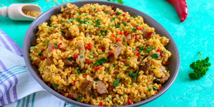 scodella piena di cous cous su piano turchese