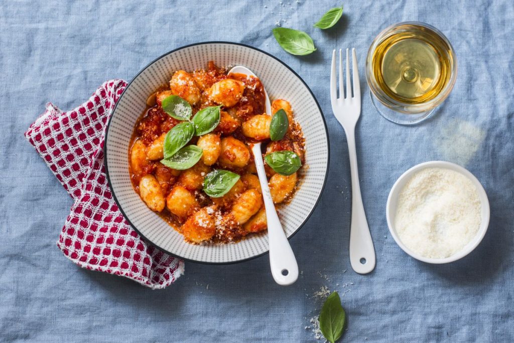 piatto tondo su fondo azzurro con gnocchi di ricotta