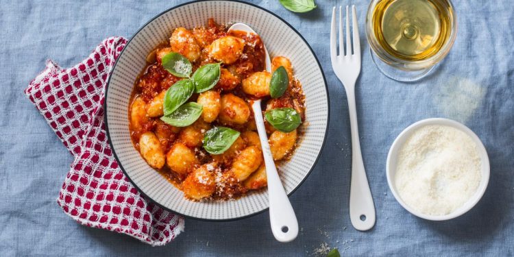 piatto tondo su fondo azzurro con gnocchi di ricotta