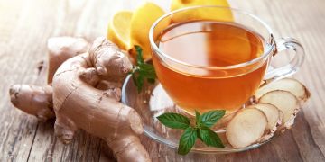 una tisana zenzero e limone in una tazza di vetro trasparente