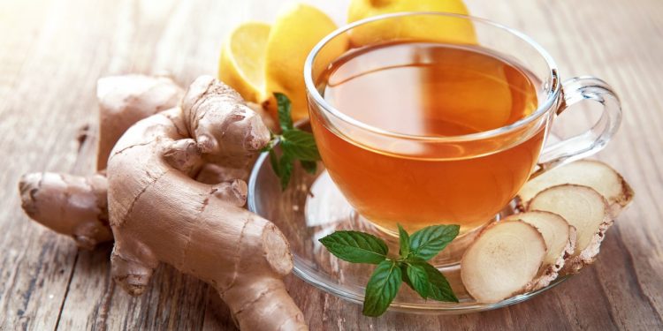 una tisana zenzero e limone in una tazza di vetro trasparente