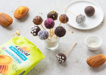un bicchiere con t bastoncini con cake pops di diversi gusti e colori