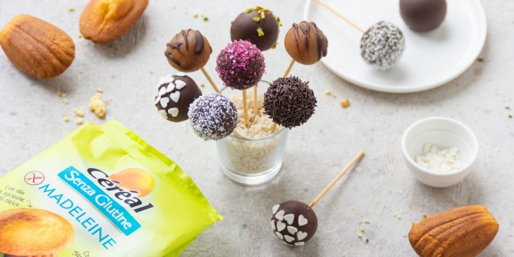 un bicchiere con t bastoncini con cake pops di diversi gusti e colori