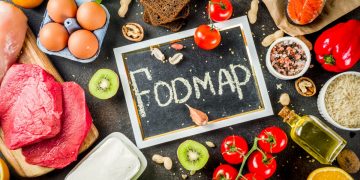 foto con al centro una lavagna con scritta FODMAP e attorno cibi come uova, pomodori, uova per descrivere la dieta per colon irrritabile