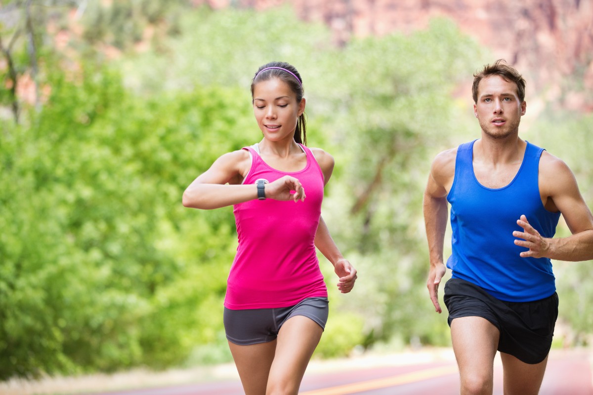 coppia che corre mentre la donna guarda il cardiofrequenzimetro