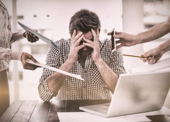 un uomo seduto al pc in preda allo stress e al cortisolo alto