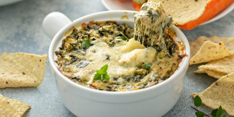 su base grigia una teglia tonda con dentro la parmigiana di carciofi
