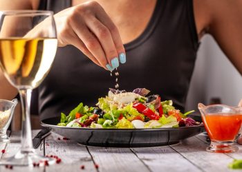 una donna che mangia un'insalata con lo sgombro