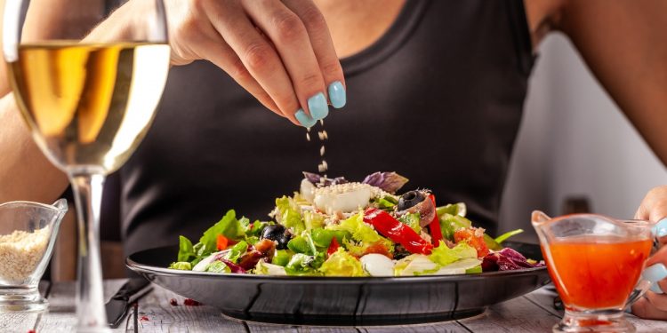 una donna che mangia un'insalata con lo sgombro