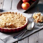 Crumble di mele: ricetta facile, croccante e golosa 1 In primo piano su un tavolo da cucina in legno c'รจ un crumble di mela.