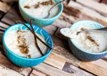 tre ciotole azzurre colme di riso al latte, su base di legno