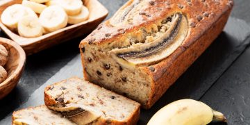 un vassoio con banana bread affettato, rondelle di banane e banana intera