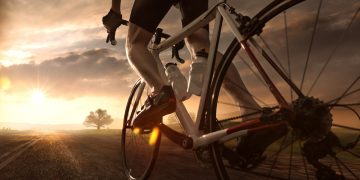 Un uomo che pedala al tramonto