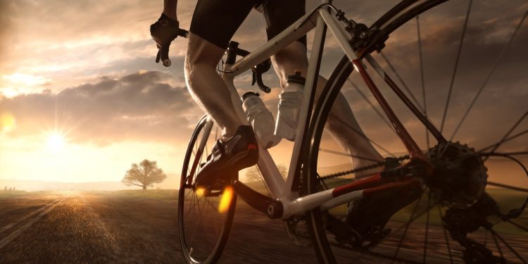 Un uomo che pedala al tramonto