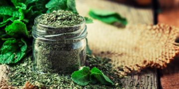 Un vasetto di vetro colmo di menta piperita essiccata