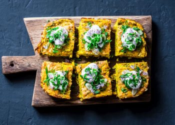 ricette con frittata: su tagliere di legno 6 tranci di frittata son sopra le verdure