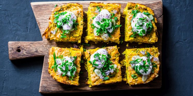 ricette con frittata: su tagliere di legno 6 tranci di frittata son sopra le verdure