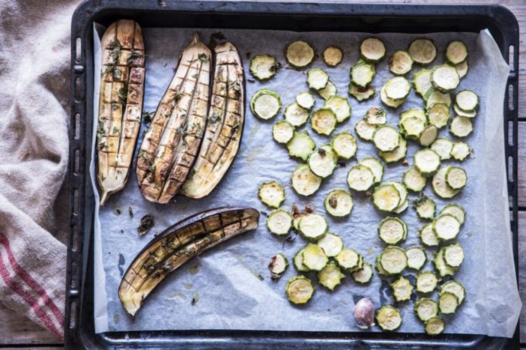 In primo piano le verdure della Buddha bowl: melanzane e zucchine cotte in forno