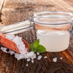 su tavolo di legno, contenitore di vetro ermetico con kefir d'acqua e accanto granuli per fare la ricetta in casa