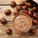 Marmellata di castagne: la versione light senza zucchero e la ricetta classica della nonna 1 sul tavolo di legno un sacchetto con castagne e una ciottola con marmellata di castagne