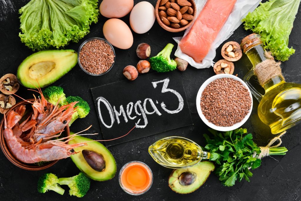 Alimenti ricchi di omega-3: quali sono e benefici per cuore e cervello 1 alcuni alimenti ricchi di omega-3 su una lavagna con la scritta Omega 3