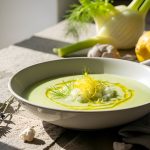 Vellutata di finocchi: la ricetta della zuppa perfetta per una pancia piatta 1 su tavolo di legno, ciotola con vellutata di finocchi, dietro u finocchio e un limone. A sinistra, sasso marino