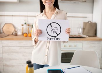 una donna in cucina mostra un cartello con scritto sugar free