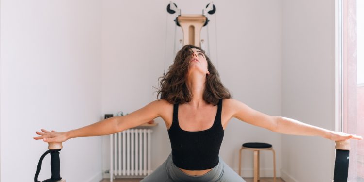 una ragazza impegnata in una sessione di Gyrotonic sullo specifico macchinario
