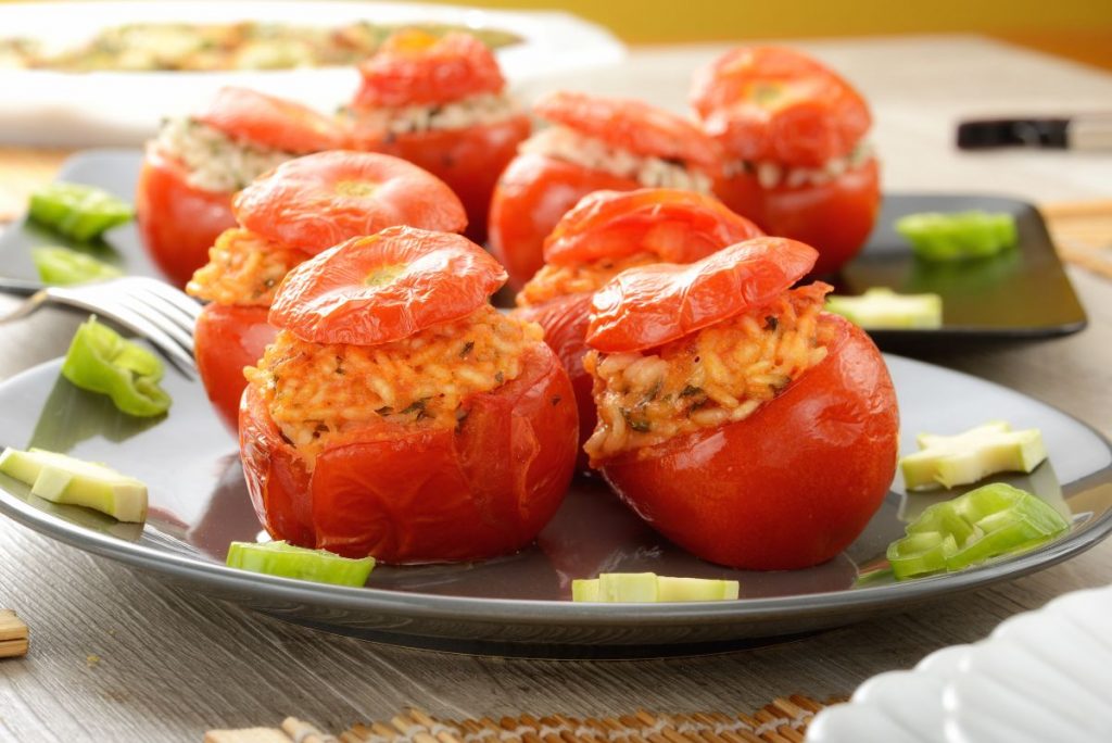 Pomodori ripieni di riso, un primo piatto facile da preparare 1 due piatti uno dopo l'altro con sopra dei pomodori ripieni di riso