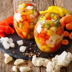 Giardiniera fatta in casa: ricetta facile con verdure croccanti 1 Giardiniera fatta in casa in barattoli con peperoni, carote, cavolfiore, sedano e cipolline.