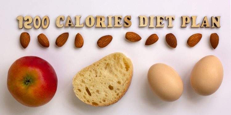 su sfondo rosa una mela, una fetta di pane 2 uova e frutta secca con la scritta in inglese: dieta da 12000 calorie
