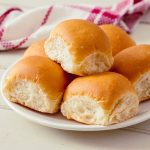 Panini all'olio fatti in casa: soffici e pronti da farcire 1 In primo piano su un piatto fondo chiaro ci sono dei panini all'olio soffici.
