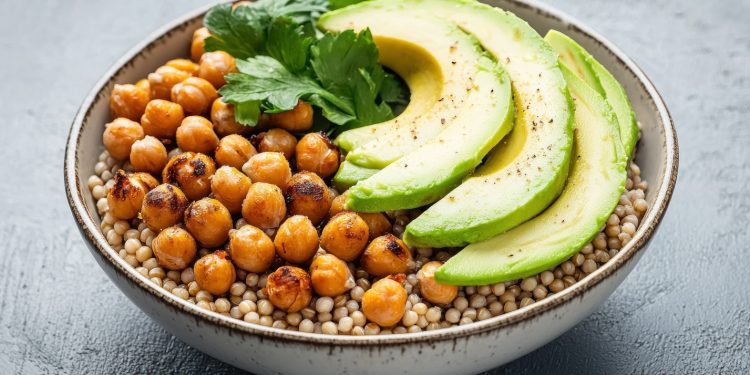 su tavolo nero, ciotola con sorgo, avocado e ceci