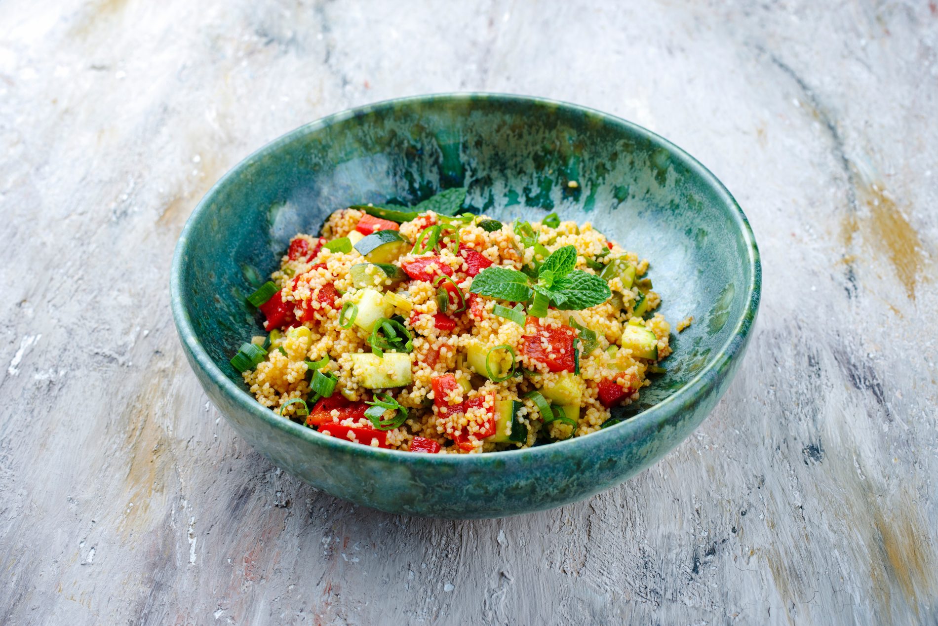 su tavolo da cucina una ciotola azzurra con una porzione di cous cous con verdure