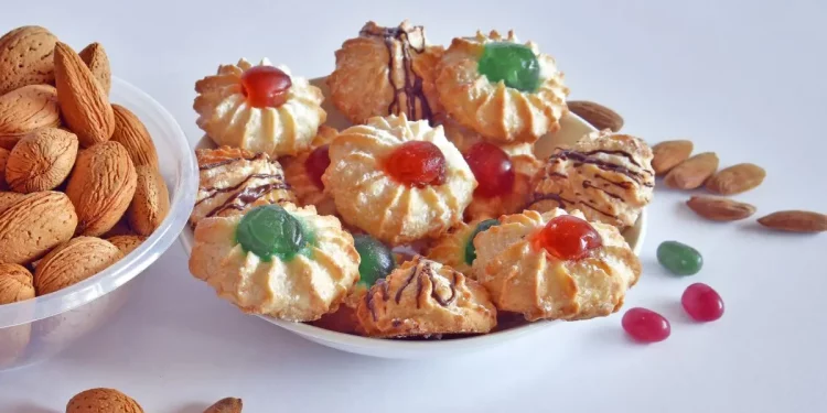 su tavolo bianco, 1 piatto con mandorle e un altro piatto bianco con pasta di mandorle, vicino