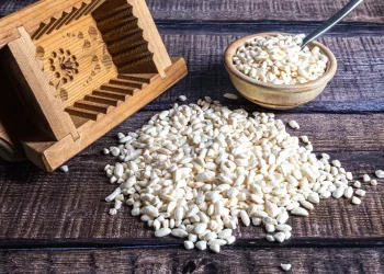 stuoie di vimini con riso soffiato sparso, ciotola di riso e cestino di legno