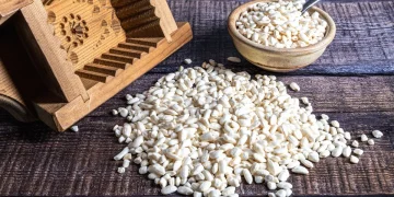 stuoie di vimini con riso soffiato sparso, ciotola di riso e cestino di legno