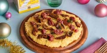 su tavolo tagliere con zampone e polenta con le palline di Natale